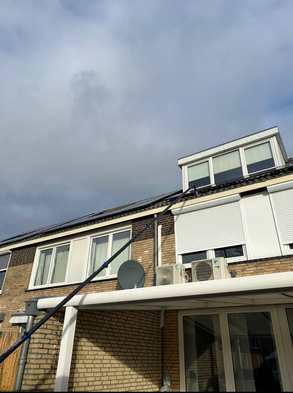 Dakgootreiniging vanaf de grond bij een woning