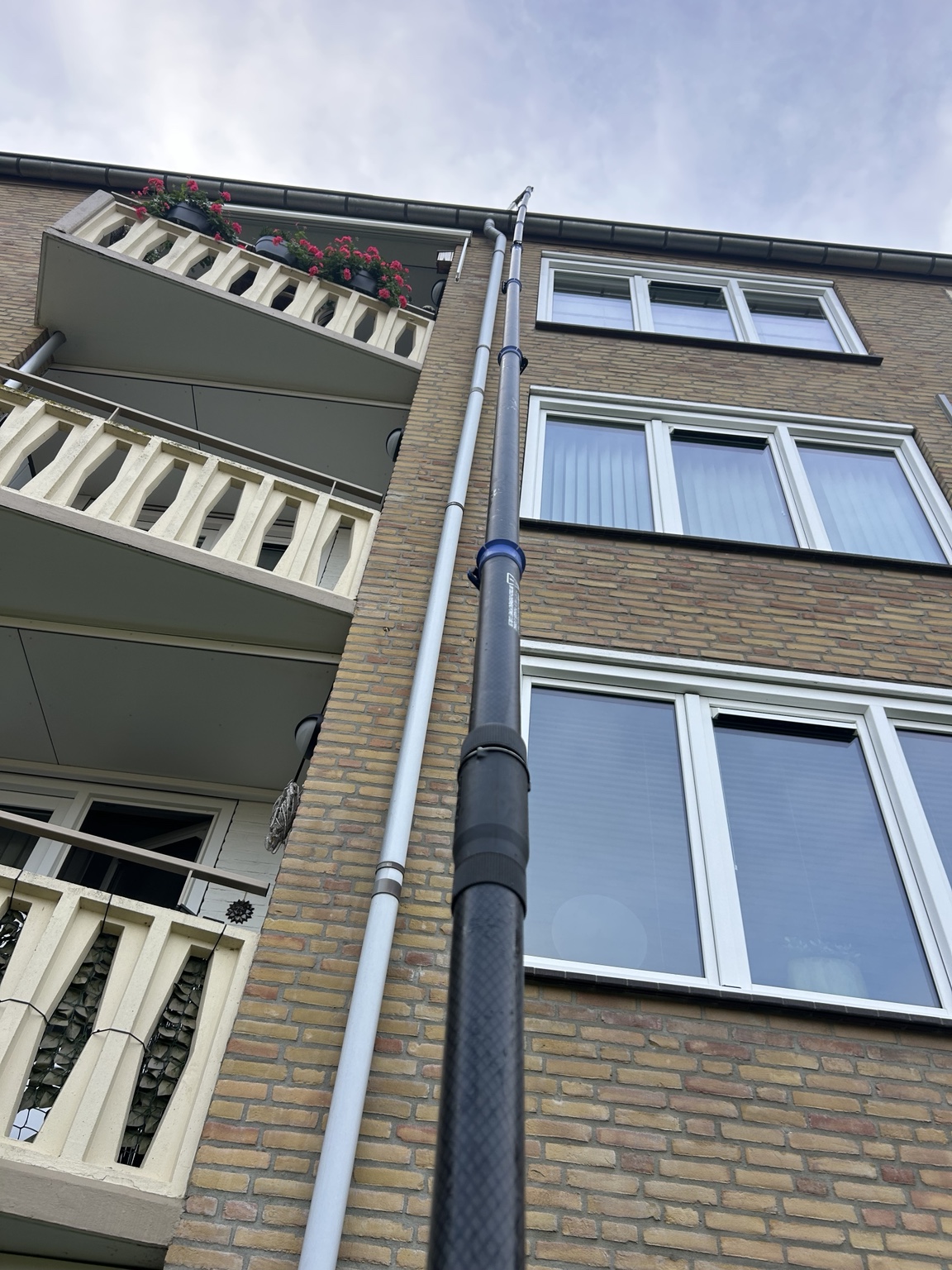 Telescoopstok reikt tot hoog aan een flat